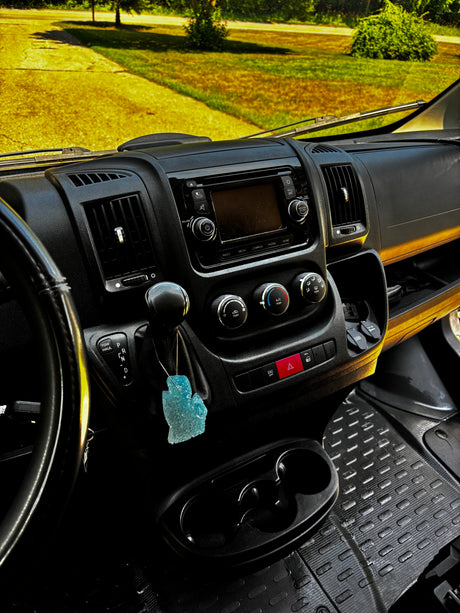 RV rental dashboard interior: media screen, climate controls, gear shifter (with TOW HAUL), cupholders, and air freshener.