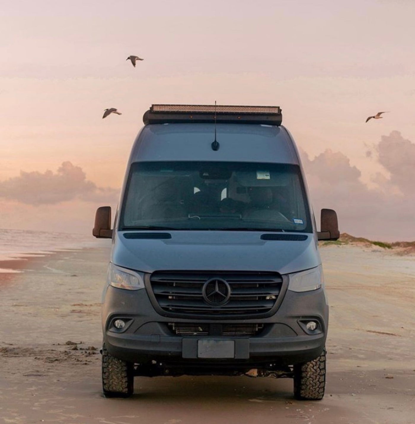  framed by mountains at sunset. Your adventure awaits!|A dark gray RV rental van — photo 7