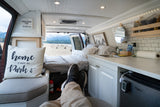 Relaxing in a cozy RV rental van with a scenic mountain view. This custom interior offers comfortable travel adventures.