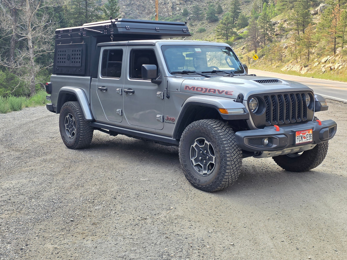 This gray Jeep Gladiator Mojave with an overland camper on a gravel road is ideal for an RV rental off-road adventure. — photo 5
