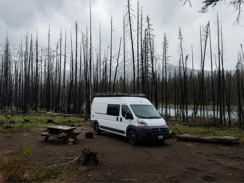  showcasing a beautiful ocean view from the rear.|Experience nature! This cozy RV rental features a bed facing an open field — photo 10