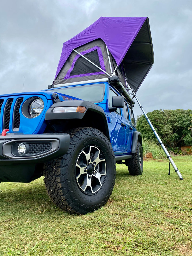 Blue Jeep Wrangler with a purple rooftop tent deployed on grass. Perfect for an RV rental camping adventure in nature. — photo 10
