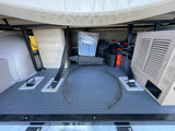 RV rental: Organized under-bed storage space with grey mat, straps, cables, and a clear bin.