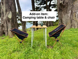 Enhance your RV rental adventure with an add-on camping table and chairs, perfect for outdoor relaxation amidst scenic nature.