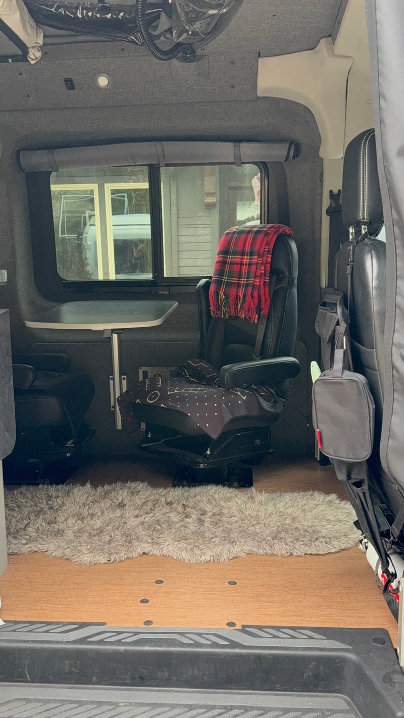 Cozy rv rental van interior with swiveling seats, a table, and a fluffy rug, ready for travel adventures. — photo 15