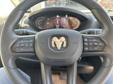 Inside an RV rental, a detailed view of the steering wheel with Ram logo, digital dash, and control buttons.