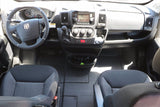 RV rental van's cockpit showing steering wheel, dashboard display, gear shifter, and front seats.