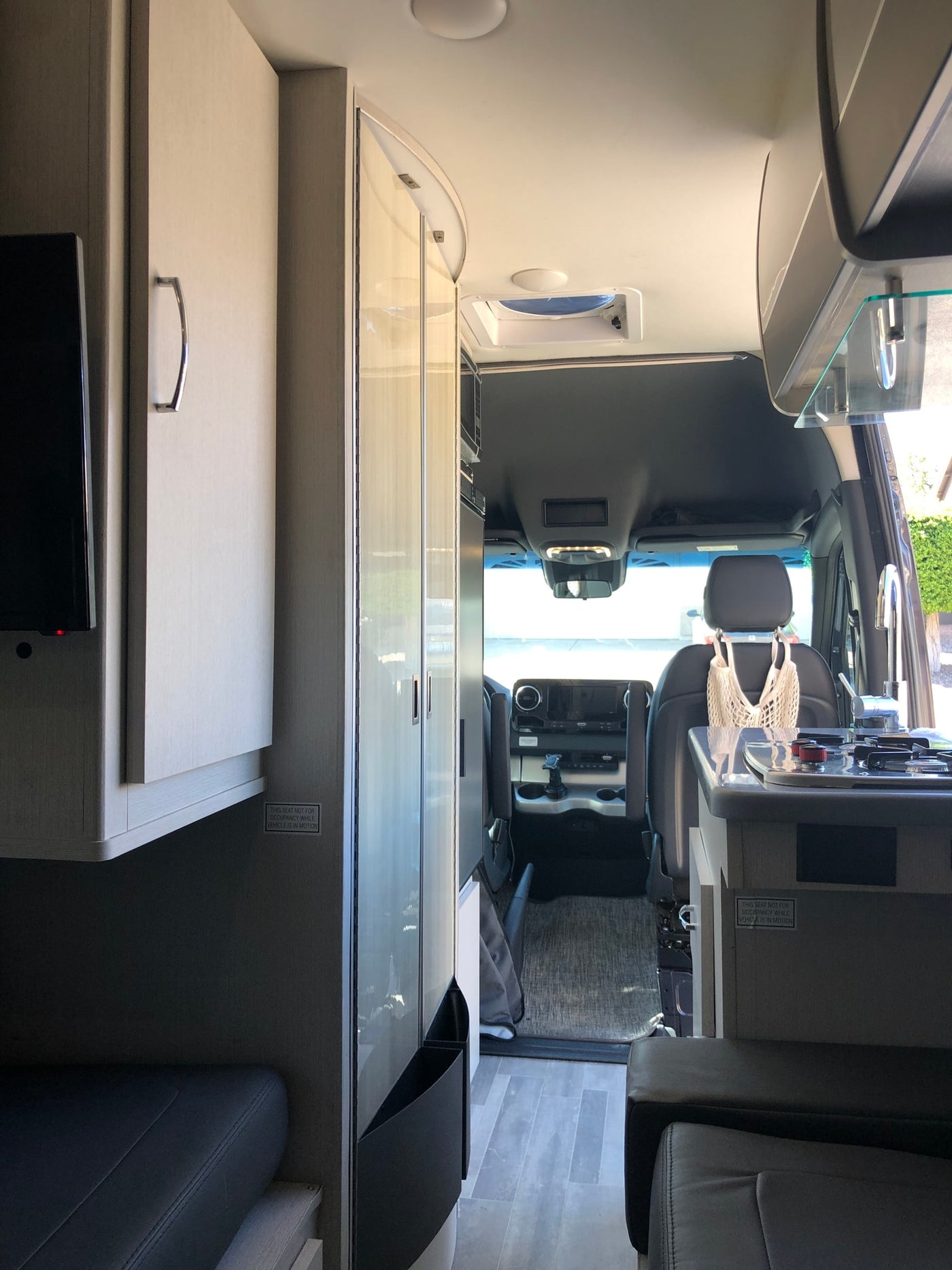  and awning for camping enjoyment.|Cozy RV rental interior with comfortable grey seating — photo 8
