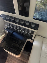 Luxury RV rental interior featuring a stylish wet bar with various glassware, sleek surfaces, and comfortable seating.