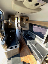This RV rental showcases a custom interior with black leather seating, wood floors, and convenient bunk beds.