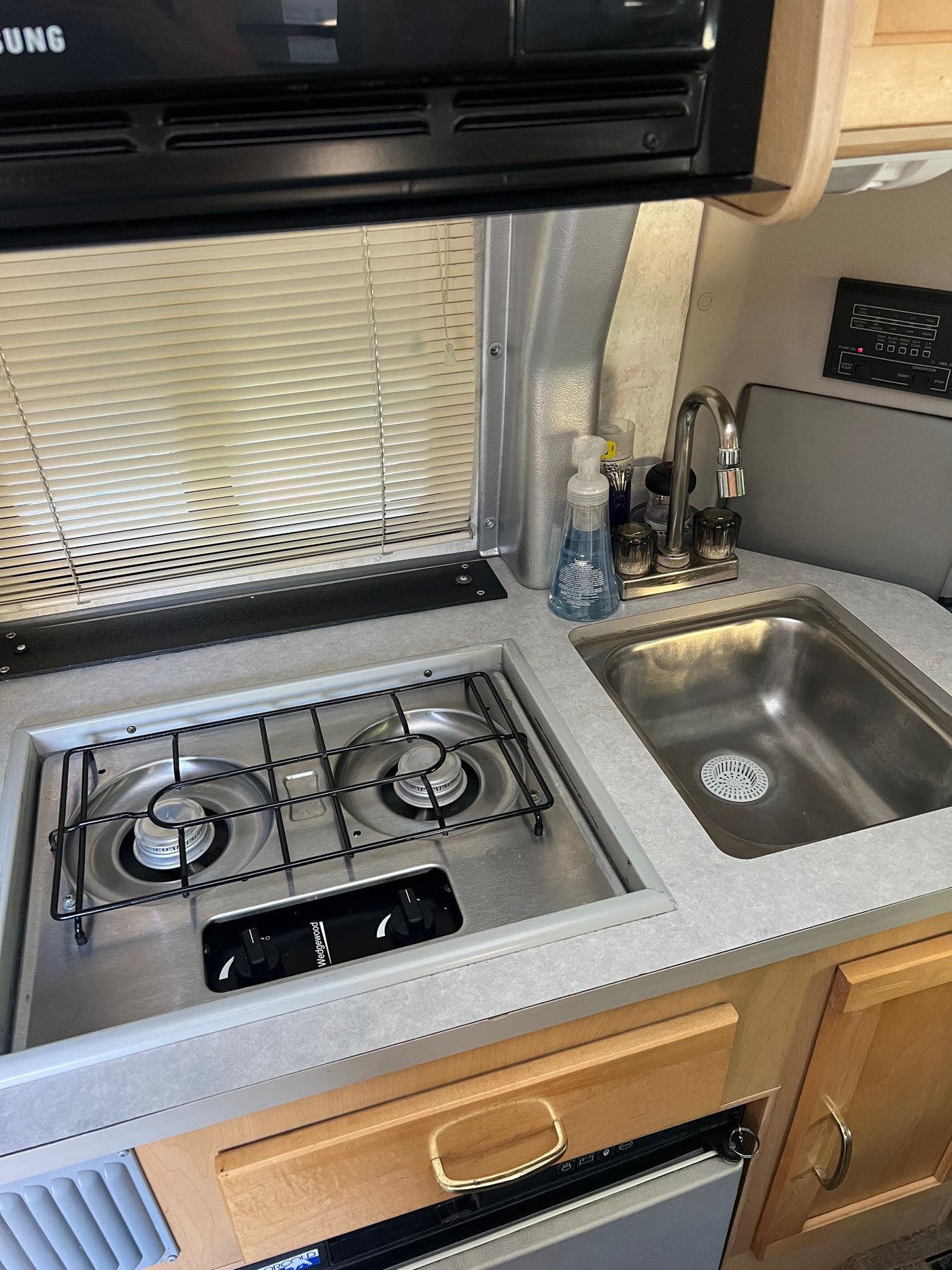 and rear seating areas.|Inside an RV rental: a compact kitchen with microwave — photo 9