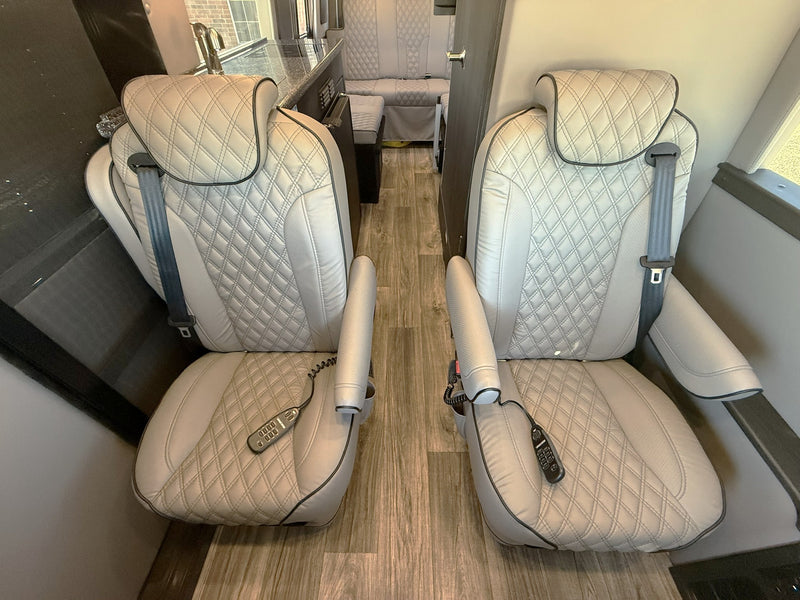  a premium rv rental. Parked on gravel under clear sky.|RV rental interior: luxurious quilted captain's chairs — photo 4