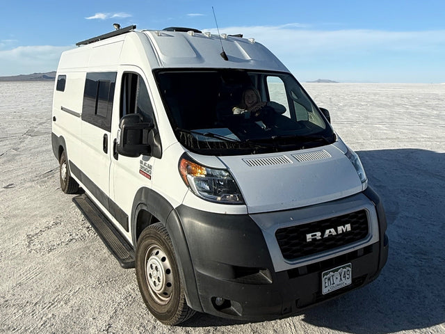 Adventure awaits! This RV rental camper van explores vast salt flats with a happy driver