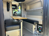 Spacious RV rental interior featuring a convertible dinette with comfy benches, adjustable table, and ample storage for your next adventure.