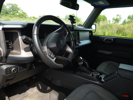 Driver's seat view of a rugged vehicle interior, ready for any rv rental adventure. Steering wheel, dashboard, and gear controls visible.