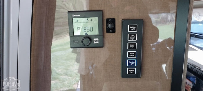 RV rental interior featuring Truma climate control and a light switch panel, with 'Awning Light' illuminated.