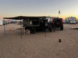 Adventure-ready **rv rental** off-road camper at a sandy desert campsite during sunset, perfect for overland travel.