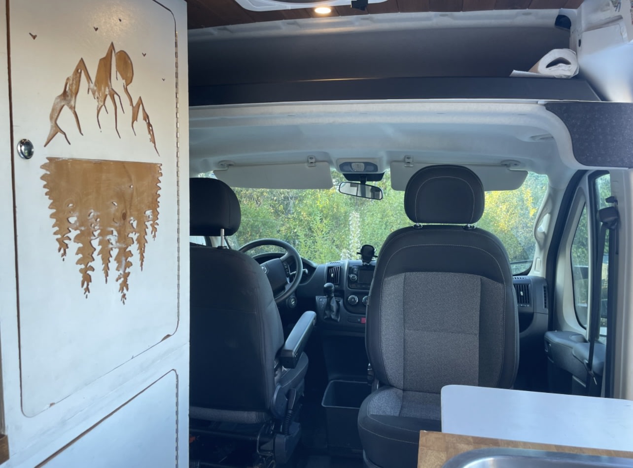  and practical storage. Perfect for adventurers!|Comfortable custom RV rental interior with a bed — photo 9