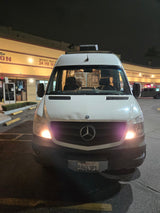 White Mercedes Sprinter van, popular for RV rentals, parked at night outside Beverly Hills shops. CA plate 59643P1.