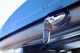 Keys in the textured lock of an RV rental roof cargo box, with a car fob.