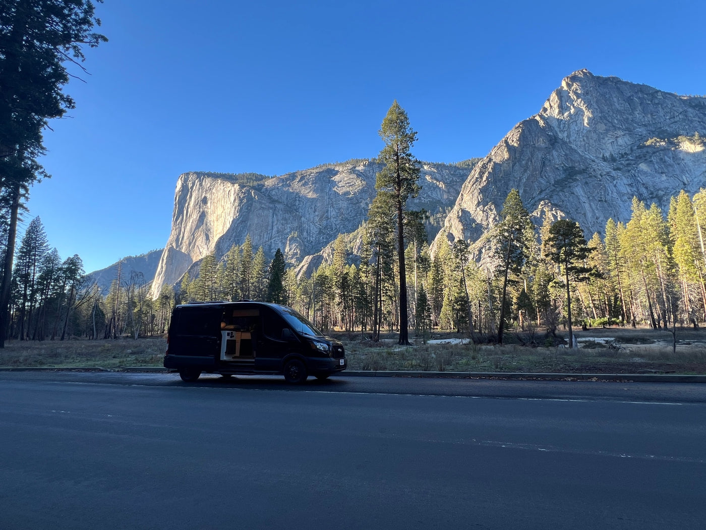 Scenic RV rental trip! A black camper van with open doors rests before Yosemite's towering El Capitan cliff. — photo 15