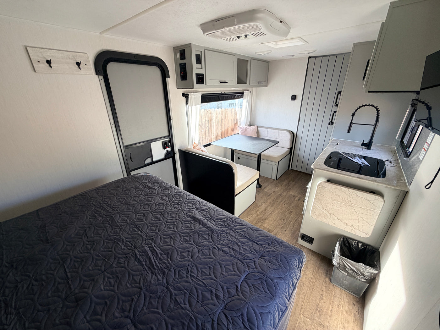 Experience comfort in this rv rental. Features a bedroom, kitchen, and dinette in a compact, modern interior. — photo 12
