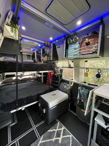 RV rental interior with bunk beds, integrated storage, and cooler. An organized, compact space for your next adventure.