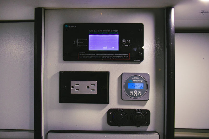 RV rental power management system: Renogy inverter module, Victron battery monitor, AC outlet, and 12V/USB ports, central to off-grid setup. — photo 6