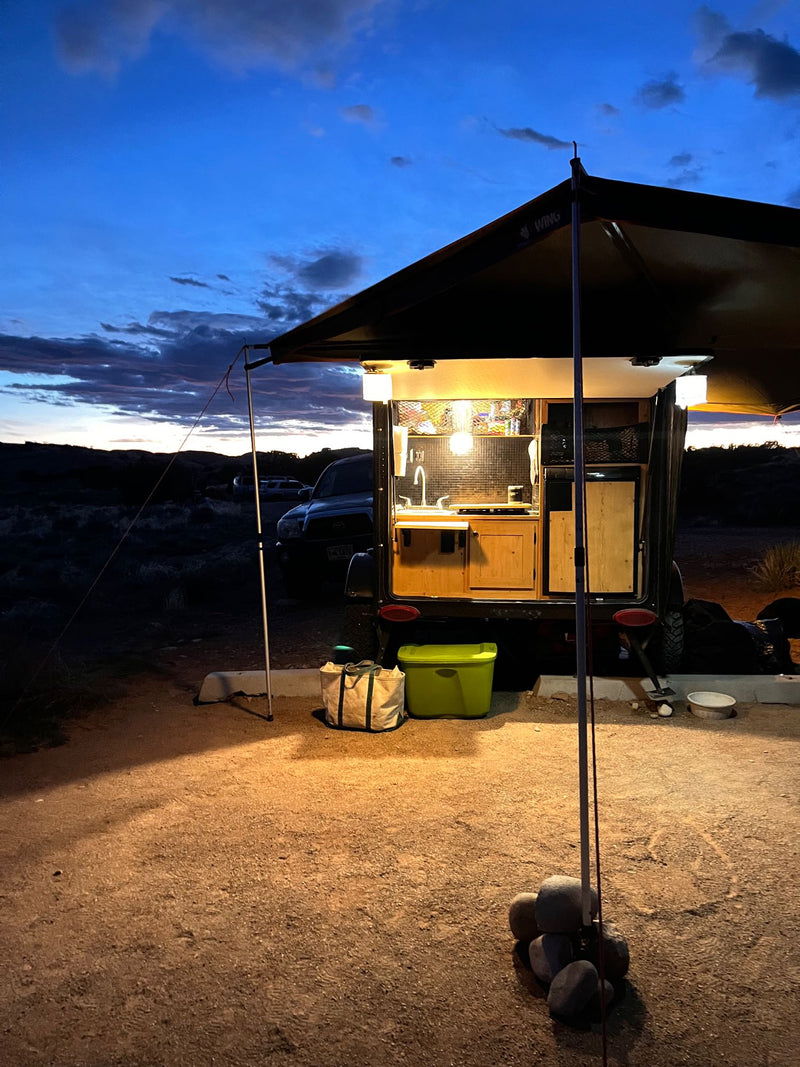  and propane tanks.|Nighttime rv rental camping scene with a lit teardrop RV under an awning and a bright campfire.|Evening RV rental setup with bikes — photo 6