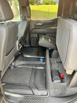 Spacious rear cabin of a truck or SUV, great for an RV rental or road trip. Shows protective floor mats & folded seat for cargo.