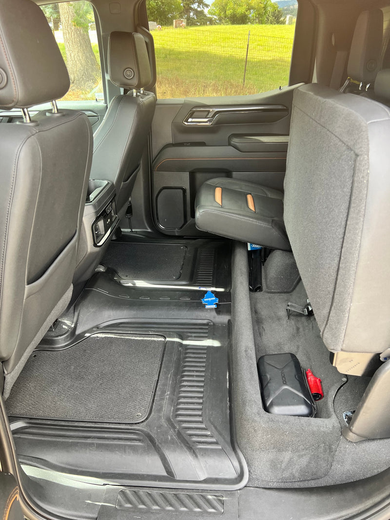 Spacious rear cabin of a truck or SUV, great for an RV rental or road trip. Shows protective floor mats & folded seat for cargo. — photo 9