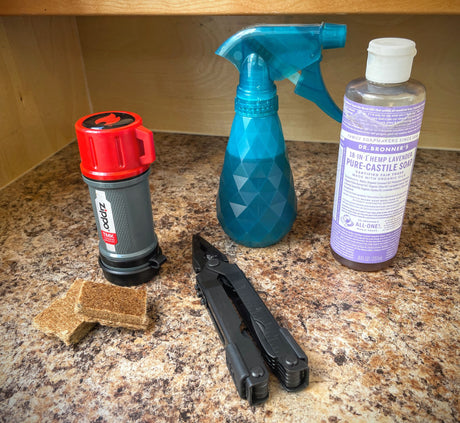 RV rental essentials: Zippo match kit, fire starters, multi-tool, Dr. Bronner's soap & spray bottle for adventure and cleaning.