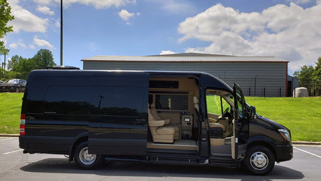Black luxury custom Sprinter van for rv rental, side door open displaying plush tan interior.