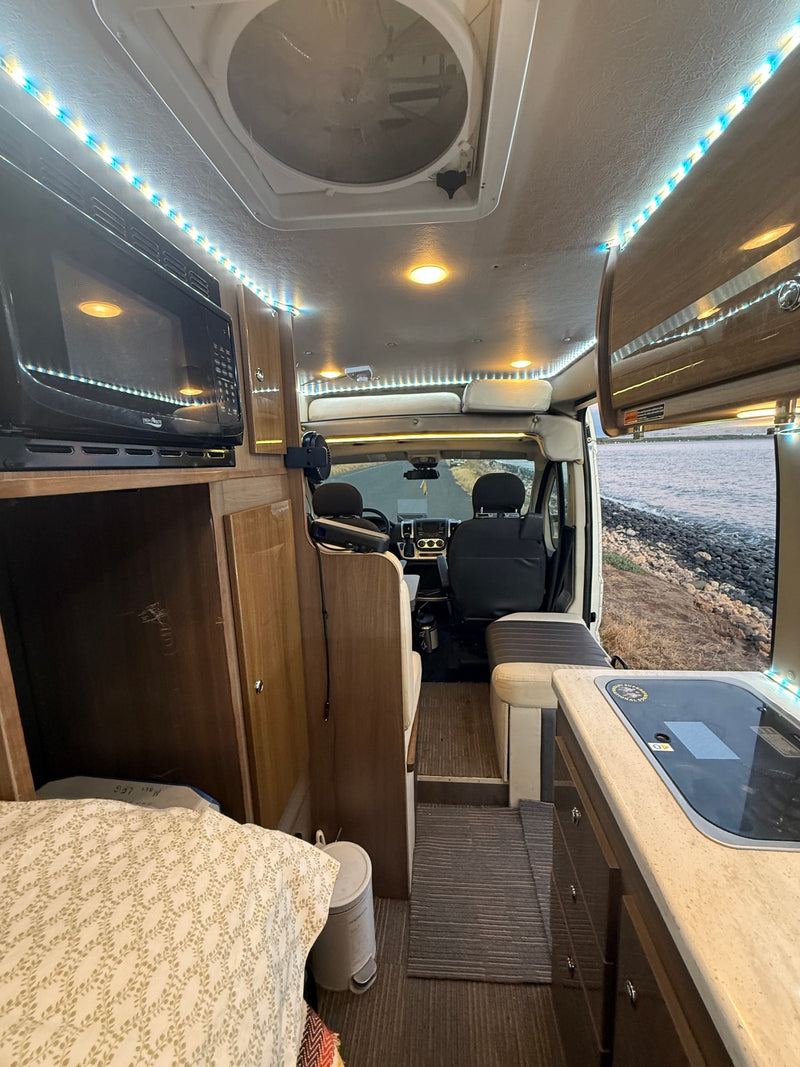 Explore in comfort with this well-equipped RV rental! Features a microwave, kitchen, and living area overlooking the water. — photo 17