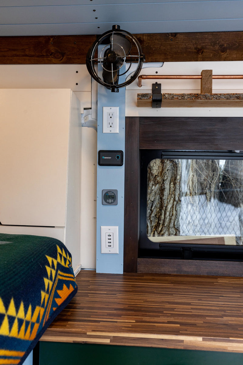  optimized for mobile living.|Cozy RV rental interior featuring a compact bed with patterned blanket — photo 13