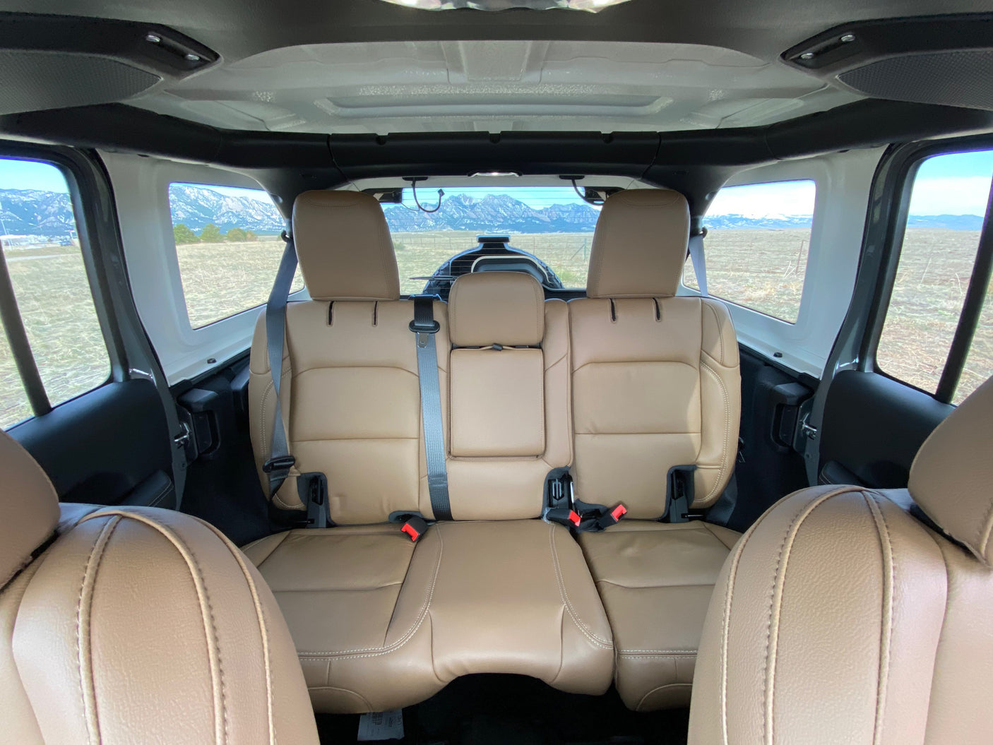 Tan interior of an off-road vehicle, looking out at mountains. Perfect for adventure trips or your next RV rental getaway.