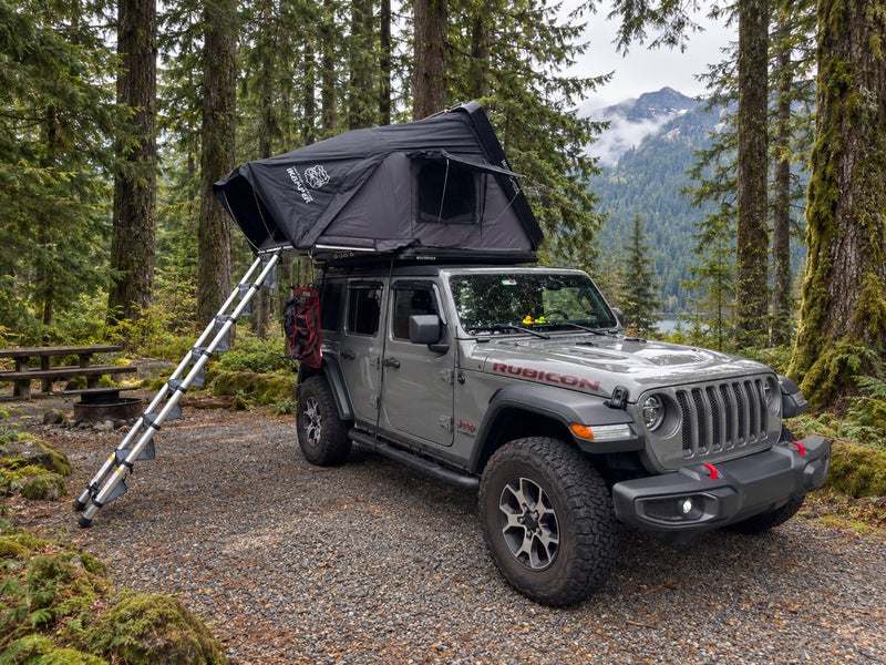 A grey Jeep Rubicon with an open iKamper rooftop tent and ladder — photo 1