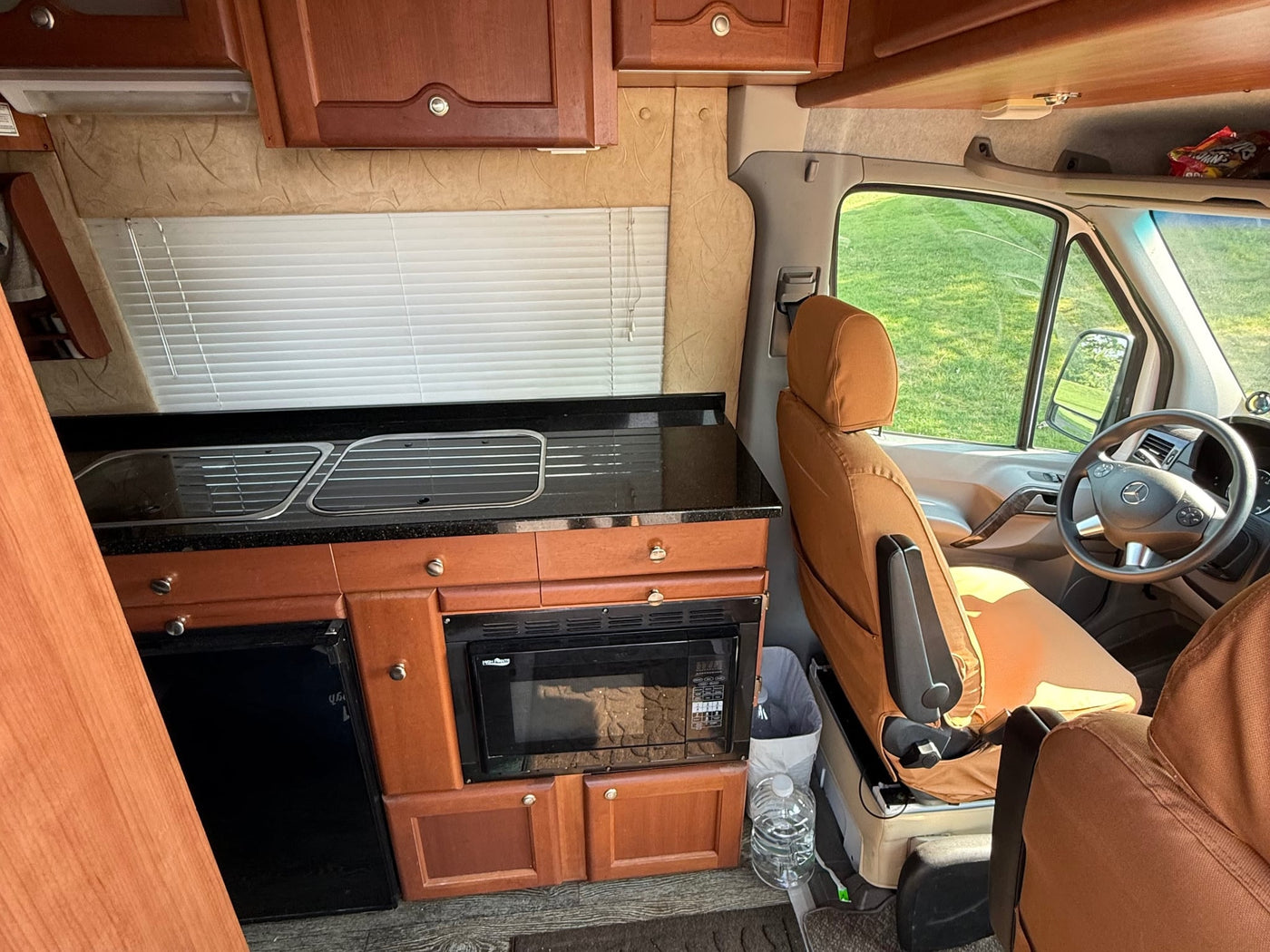  revealing a bug screen & comfortable interior bed.|Inside this RV rental: a compact kitchen with sink — photo 11