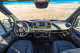 Spacious RV rental van interior featuring a modern cockpit, dashboard, leather seats, and open desert views.