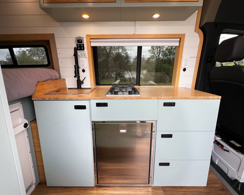  and stunning ocean view from the windshield.|Explore this modern camper van RV rental interior! Features a custom light blue kitchenette — photo 6