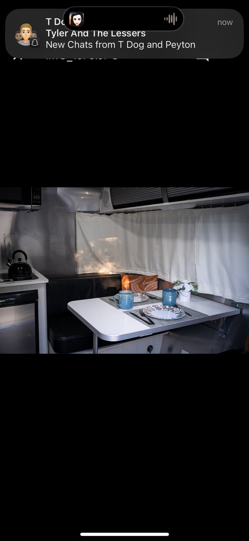 Experience comfort in this RV rental! Interior features a dining area for two, complete kitchen, and sleek metallic walls. — photo 6