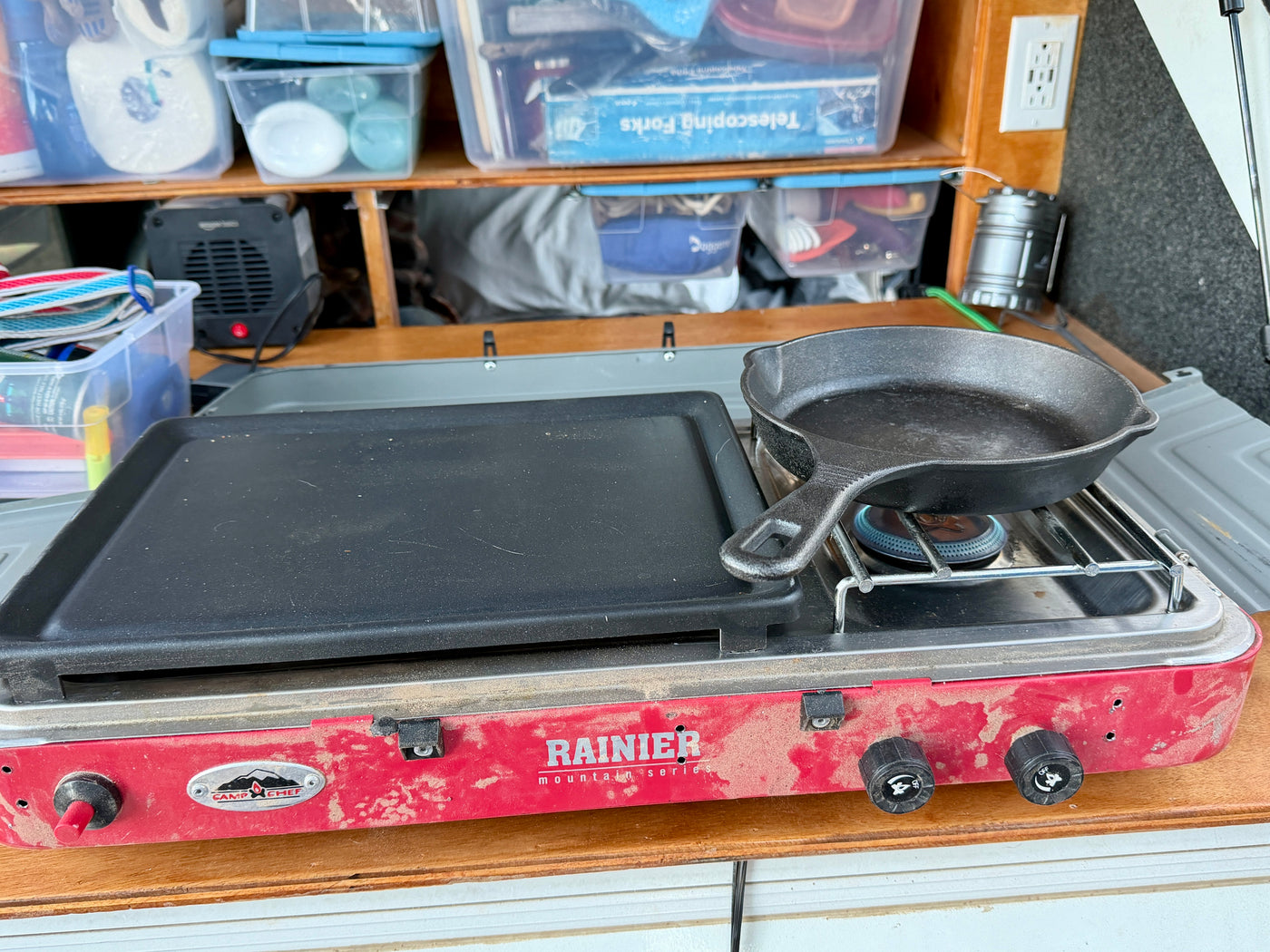 **RV rental** kitchen featuring a dusty Camp Chef Rainier stove with a cast iron skillet and griddle for cooking. — photo 15