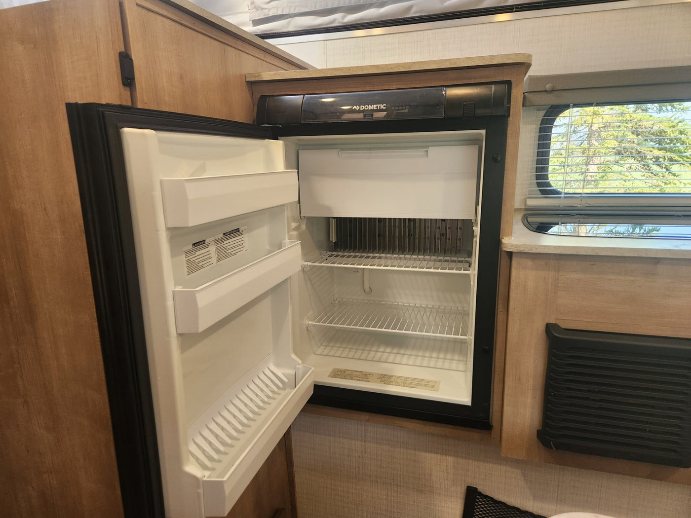  and dinette area visible.|Bright RV rental interior: a comfortable dinette with light wood table — photo 8