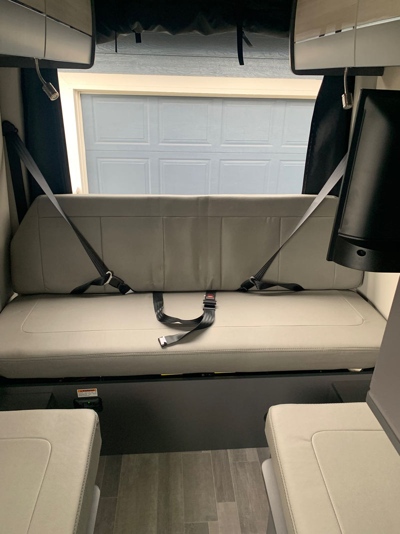  with side door open & awning extended at a home.|Interior of an rv rental features a gray convertible bed/seating area — photo 15
