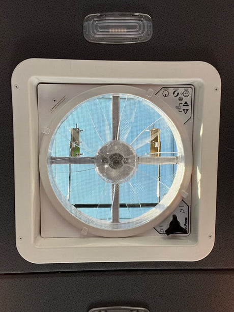 RV rental ceiling fan/vent with screen & controls (on/off, auto, open/close knob), showing a sunny sky.