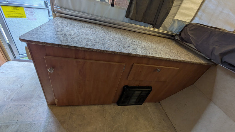  and countertop. Ideal for camping trips.|This rv rental's pop-up interior shows a bed with a vibrant yellow and green mattress — photo 4