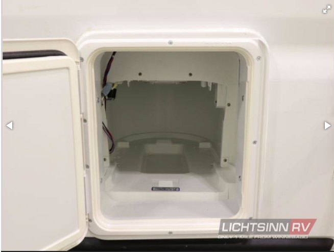 RV rental shows an open exterior utility bay. This white, empty housing has visible wiring for various uses.