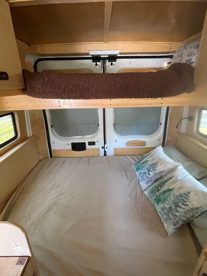 RV rental: Interior view of a custom-built camper van with a cozy bed and overhead bunk for storage. — photo 6