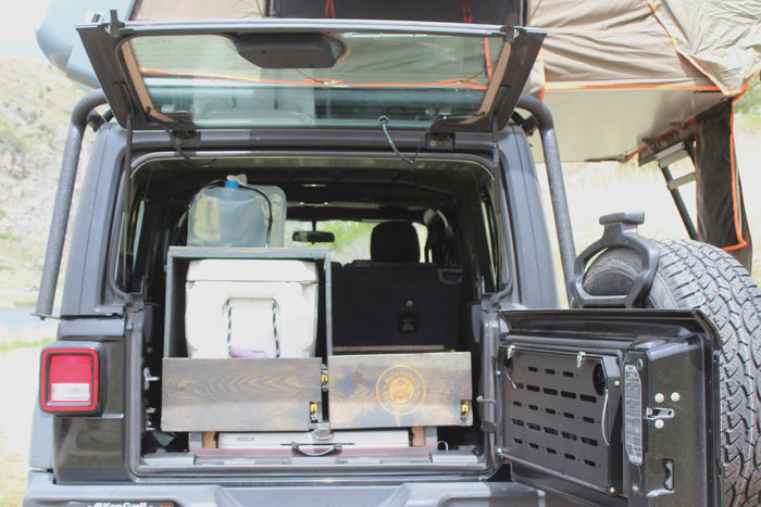 Open Jeep Wrangler with overland storage, cooler, water, and rooftop tent. Ideal for your next RV rental camping trip!