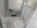 This RV rental features a compact wet bath with a toilet, shower, and toilet paper holder, maximizing space.